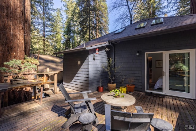 wooden deck with french doors and outdoor dining area