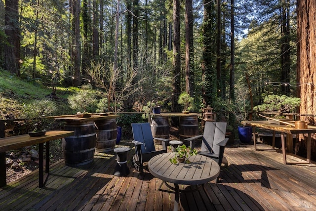 wooden terrace featuring a view of trees