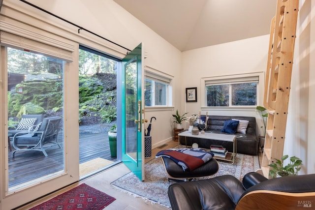 doorway with lofted ceiling, wood finished floors, plenty of natural light, and visible vents