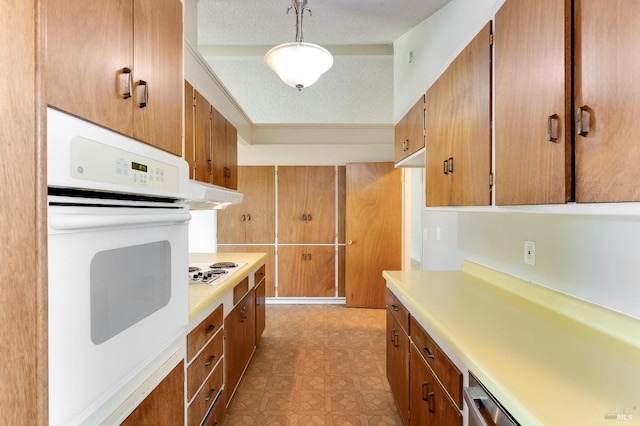 1740 Sereno Dr, Vallejo, CA 94589 - kitchen with brown cabinetry, under cabinet range hood, light countertops, and white appliances