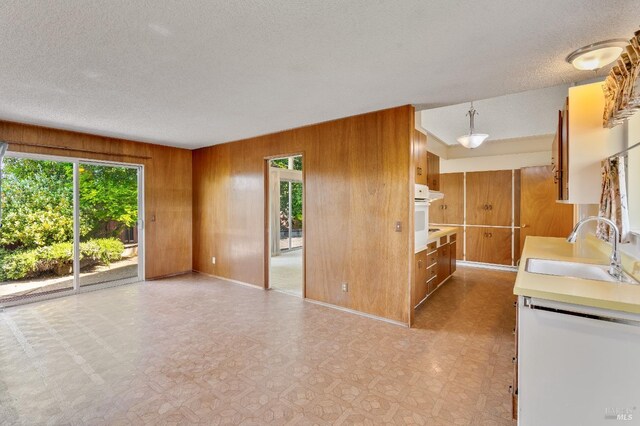 1740 Sereno Dr, Vallejo, CA 94589 - kitchen featuring a sink, light countertops, plenty of natural light, and wooden walls