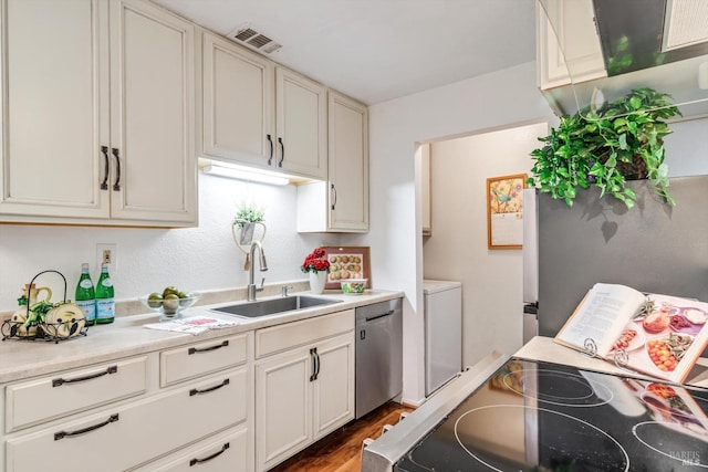 kitchen with a sink, stainless steel appliances, visible vents, light countertops, and dark wood finished floors