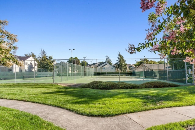 view of sport court with a residential view, a yard, and fence