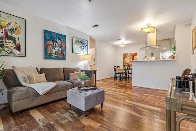 living area featuring wood finished floors and visible vents