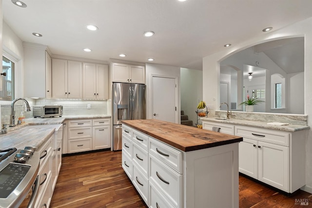 kitchen featuring stainless steel appliances, white cabinets, and wooden counters