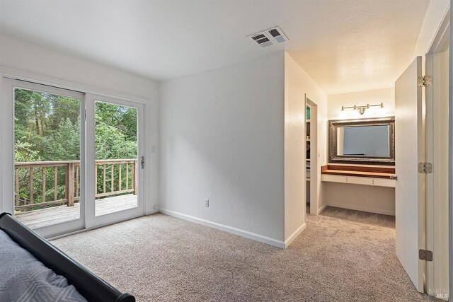 unfurnished bedroom with visible vents, access to outside, baseboards, and carpet floors