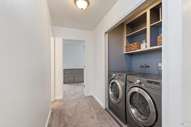 clothes washing area featuring laundry area, carpet flooring, washing machine and clothes dryer, and baseboards