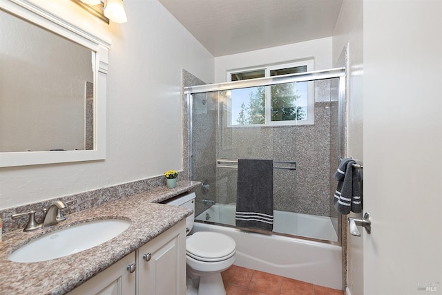 bathroom with toilet, tile patterned floors, vanity, and shower / bath combination with glass door