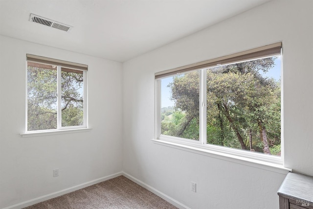 empty room with visible vents, baseboards, and carpet floors