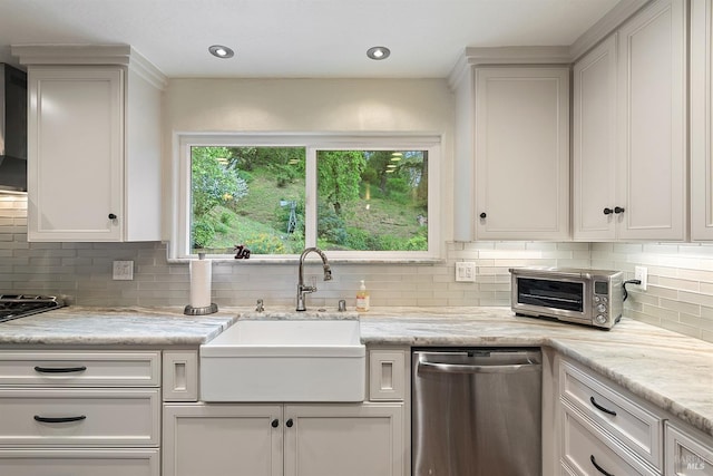 kitchen featuring a toaster, white cabinetry, backsplash, dishwasher, and a sink