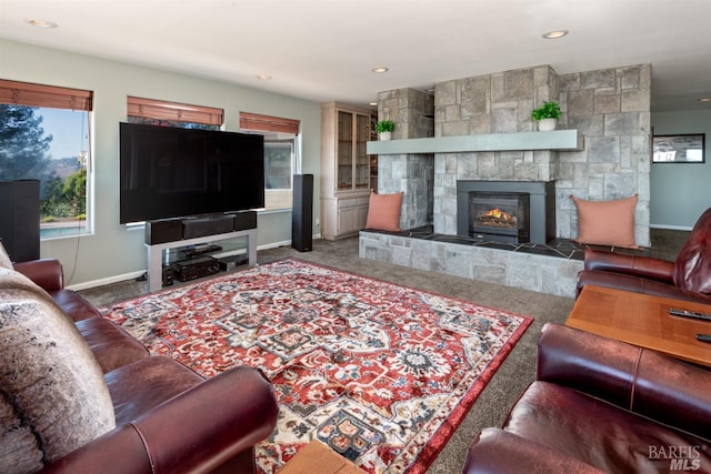 carpeted living area with recessed lighting, a tile fireplace, and baseboards