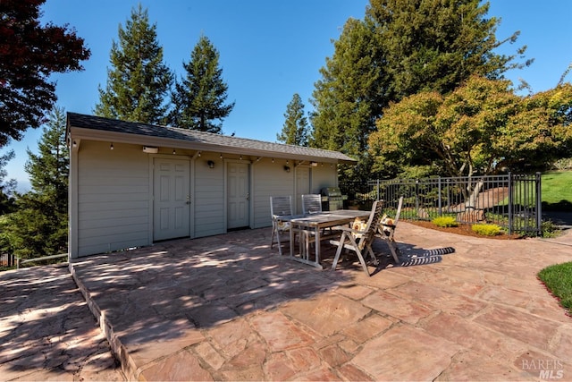 view of patio featuring grilling area, outdoor dining space, and fence