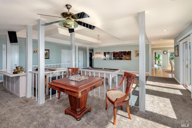 rec room featuring baseboards, a tray ceiling, a ceiling fan, and carpet floors