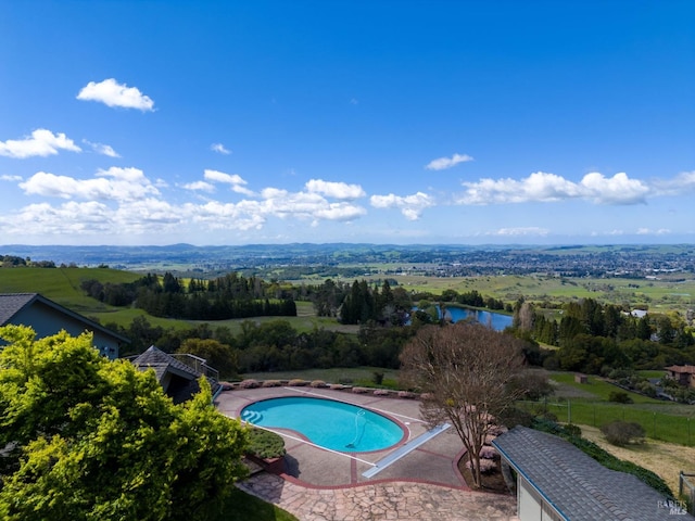 view of swimming pool with a fenced in pool and a water view