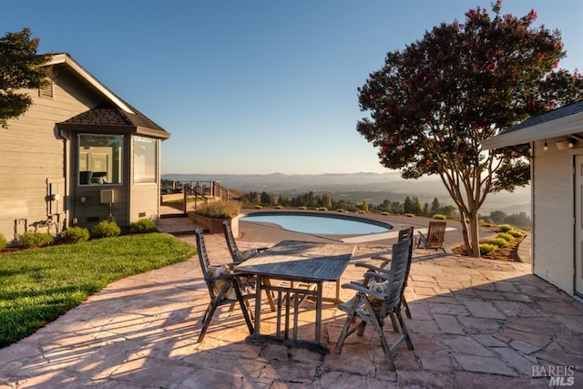 view of patio with an outdoor pool and a mountain view