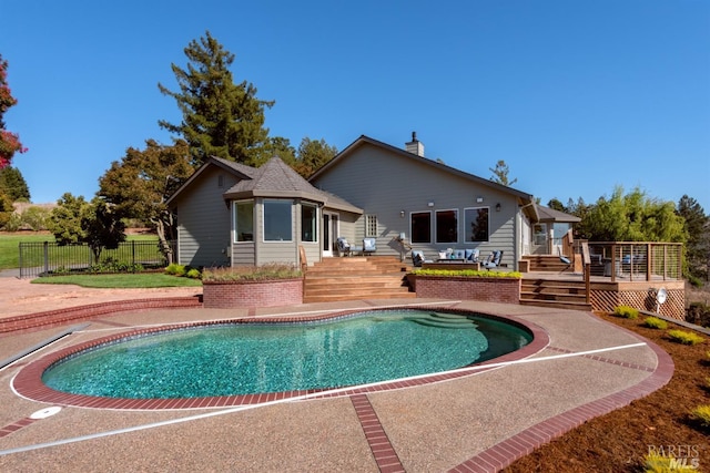 view of swimming pool featuring a fenced in pool, a wooden deck, and fence