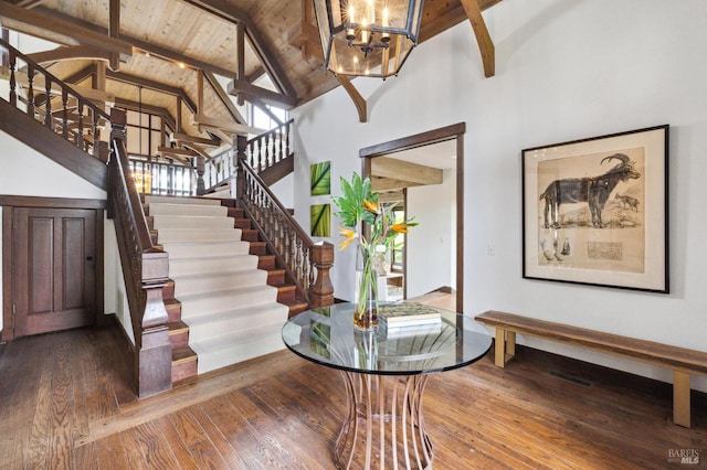 foyer with hardwood / wood-style floors, wooden ceiling, beam ceiling, and stairs