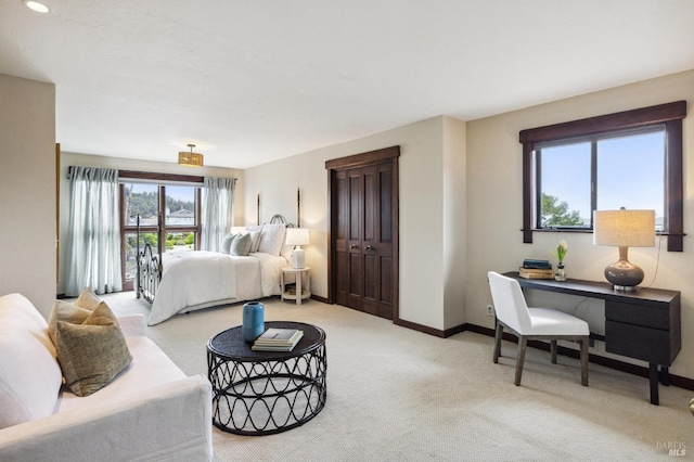 bedroom featuring light colored carpet and baseboards