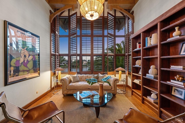 living area with baseboards and a high ceiling