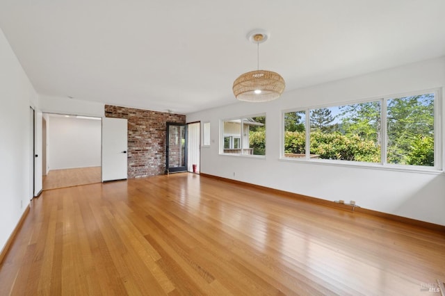 unfurnished living room featuring light wood finished floors and baseboards