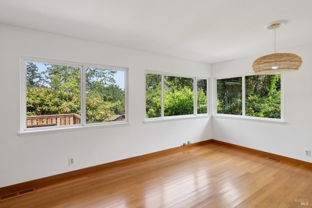 unfurnished sunroom featuring visible vents and a wealth of natural light