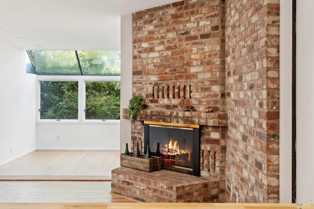 unfurnished living room featuring wood finished floors, a fireplace, and baseboards
