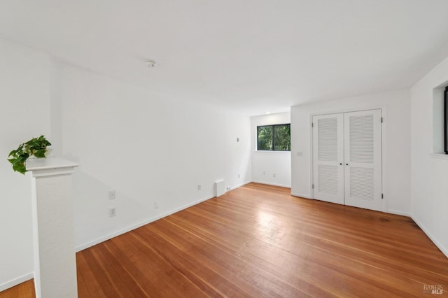 unfurnished bedroom with baseboards and light wood-style flooring