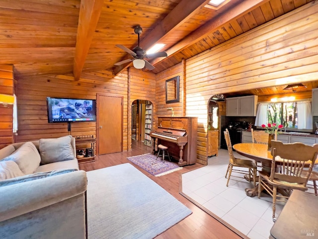 living room with light wood-style flooring, arched walkways, wooden ceiling, and vaulted ceiling with beams
