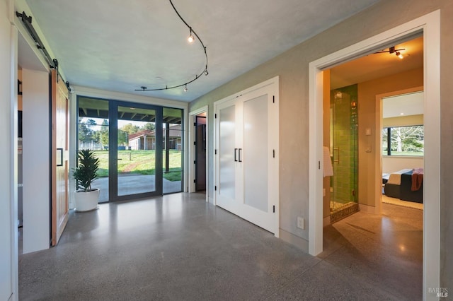 interior space with french doors, rail lighting, and a barn door