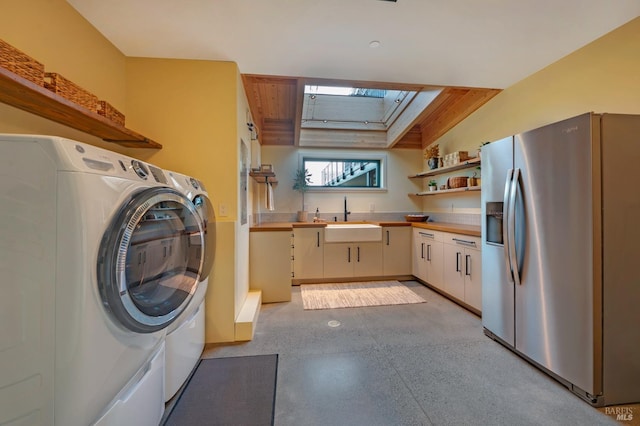 washroom with a skylight, laundry area, and a sink