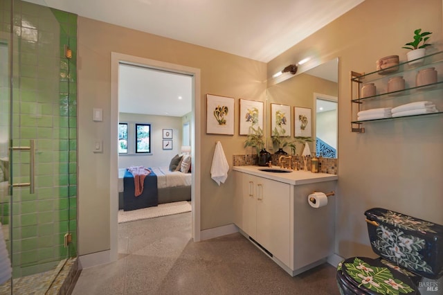 bathroom featuring baseboards, ensuite bath, vanity, speckled floor, and tiled shower
