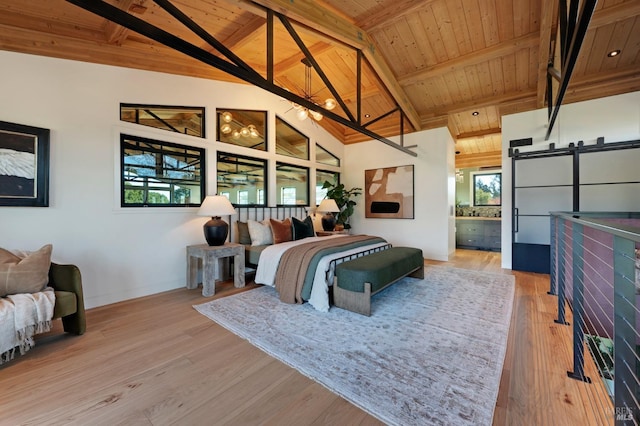 bedroom featuring multiple windows, a barn door, wood finished floors, and wood ceiling