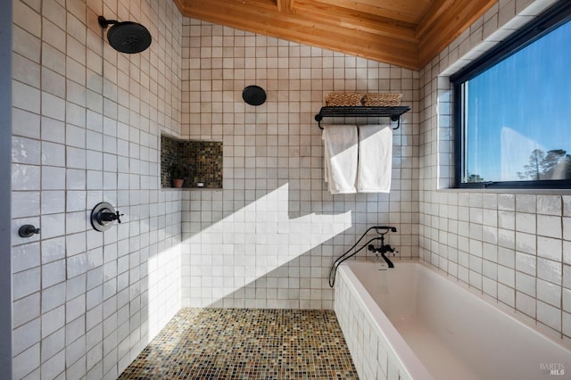 full bathroom featuring tiled shower, a bath, tile walls, and vaulted ceiling