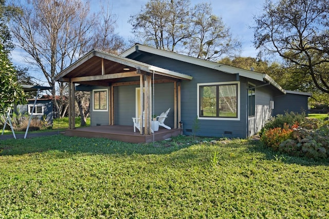 rear view of house featuring crawl space, a yard, and a porch