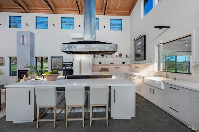 kitchen featuring a sink, a high ceiling, backsplash, beam ceiling, and wooden ceiling