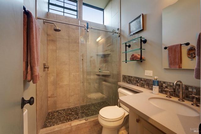 bathroom with vanity, a stall shower, backsplash, and toilet