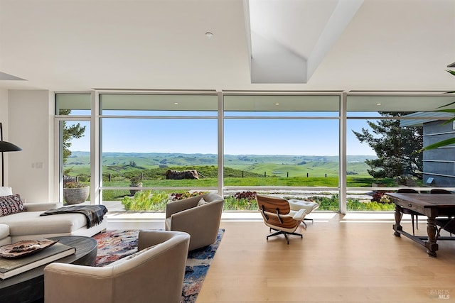 living room with a healthy amount of sunlight, a mountain view, and wood finished floors