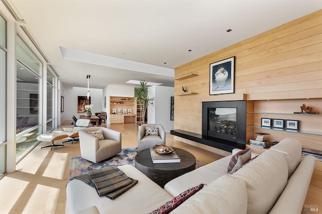 living area featuring wooden walls and a multi sided fireplace