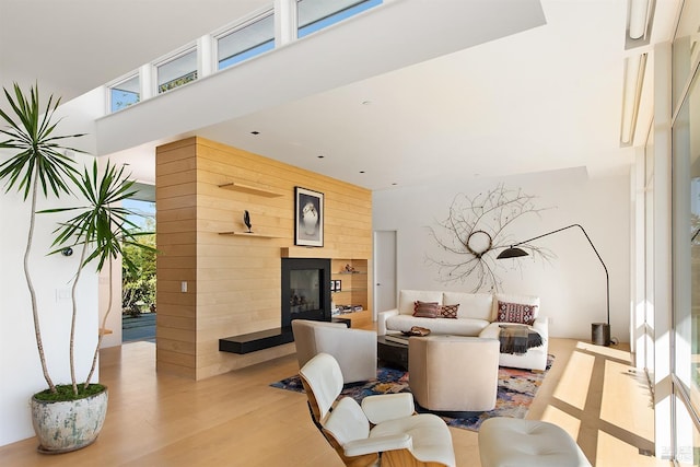 living room featuring a towering ceiling and wood finished floors