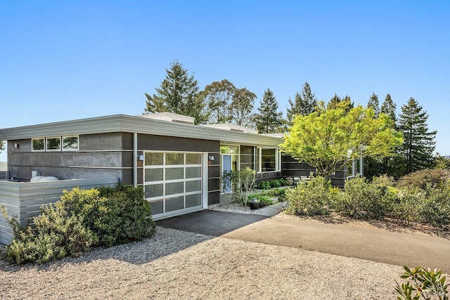 mid-century home featuring an attached garage and driveway