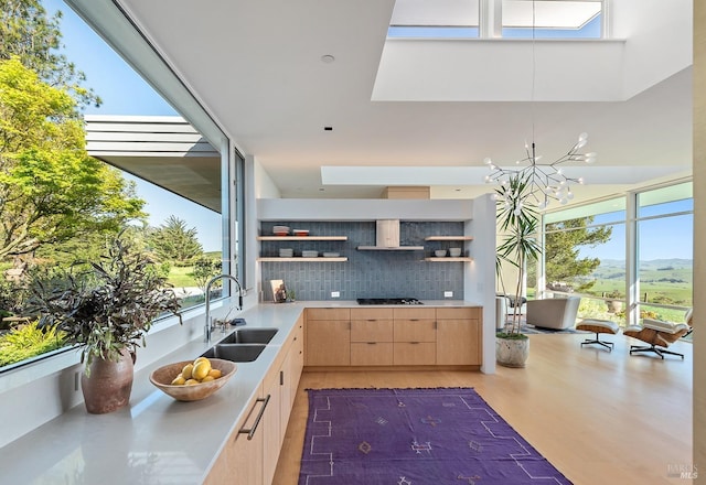 kitchen with tasteful backsplash, light countertops, open shelves, a sink, and light brown cabinetry