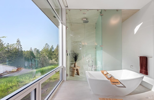 full bath with a shower stall and a freestanding tub