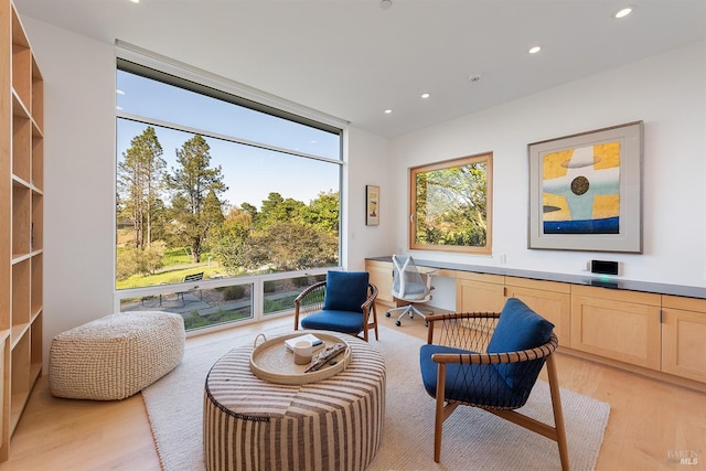 sitting room with recessed lighting, expansive windows, and light wood-type flooring