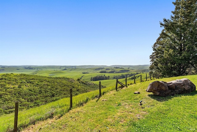view of yard featuring a rural view and fence