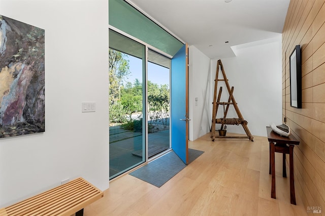 doorway to outside with wood finished floors and a wall of windows