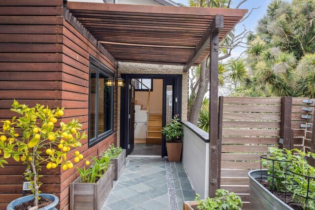 view of side of property with fence and a pergola