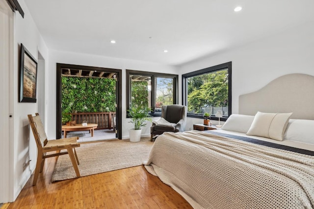 bedroom with light wood finished floors, recessed lighting, and access to exterior