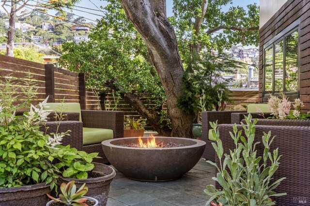 view of patio featuring fence and a fire pit