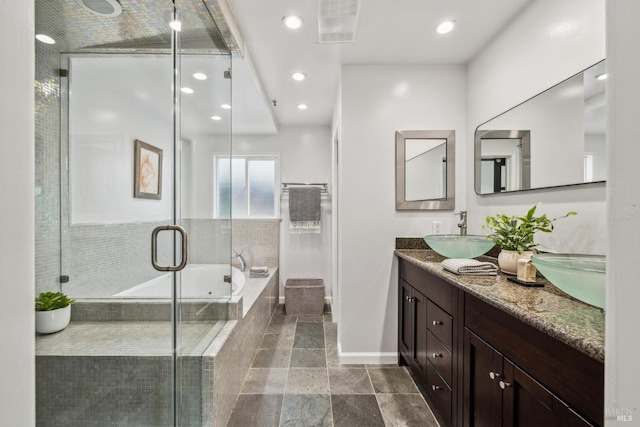 full bathroom featuring a sink, double vanity, baseboards, visible vents, and a garden tub