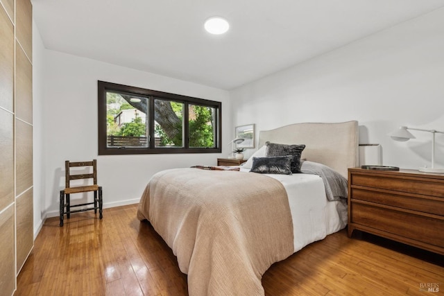 bedroom with baseboards and hardwood / wood-style flooring